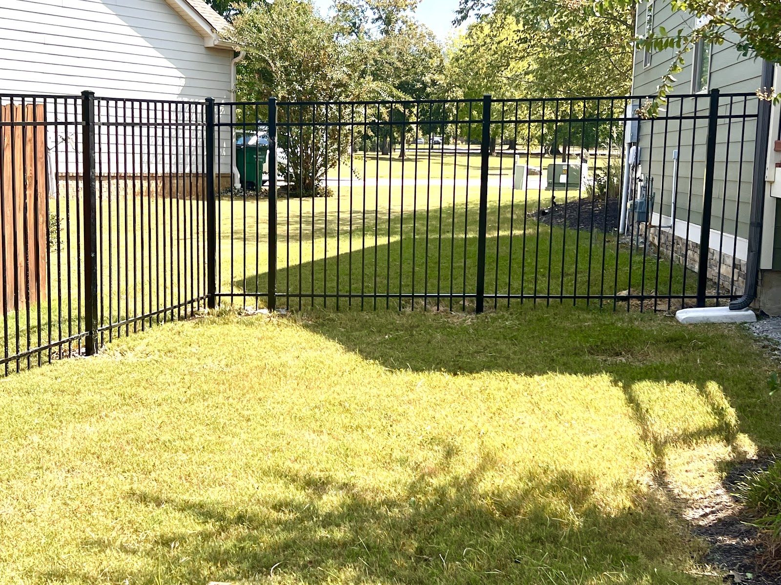 Black aluminum backyard fence and gate built by Siler Fence Company